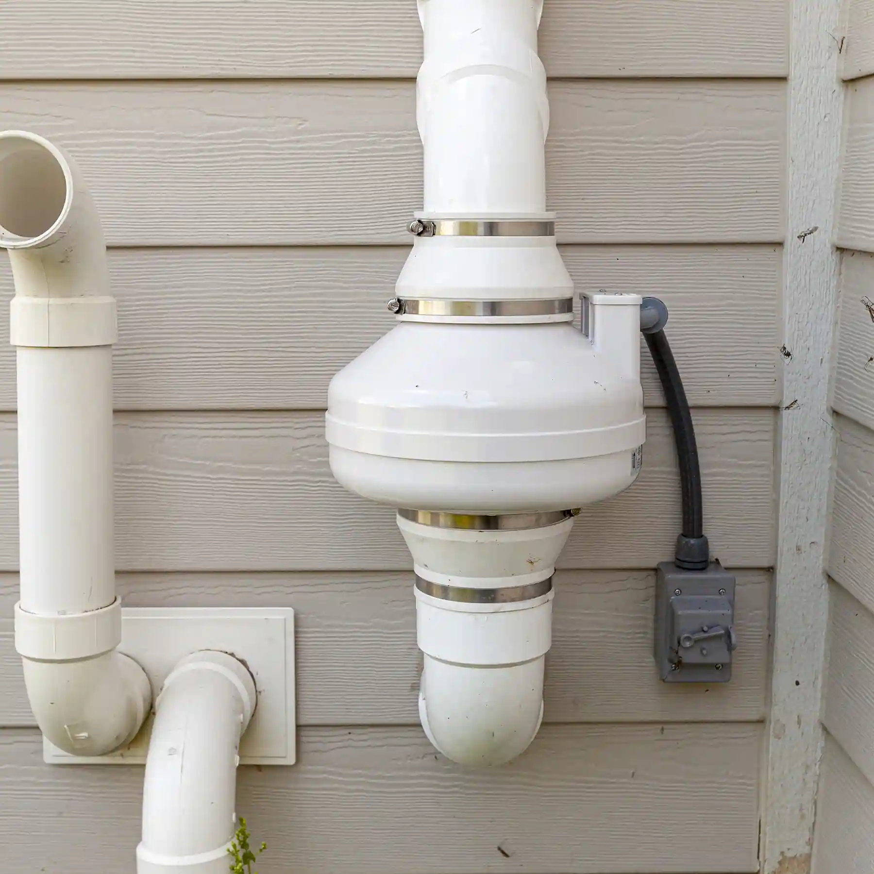 Radon vent pump mounted to the outside of a home to evacuate harmful radon from a house. 